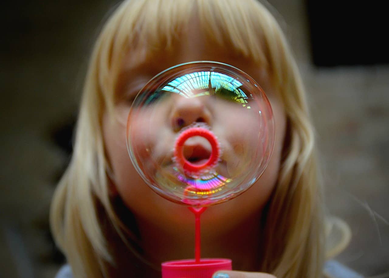 Girl Blowing a soap bubble.